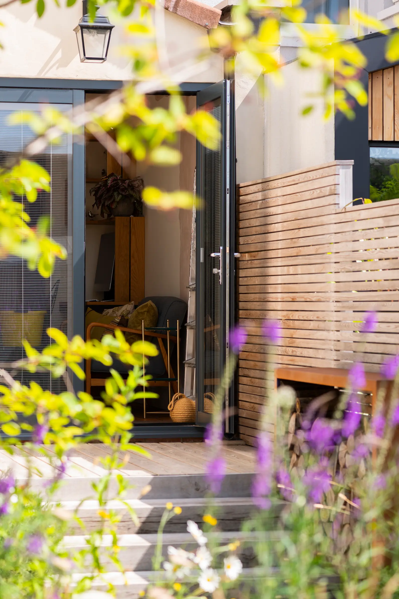 A cozy entrance surrounded by colorful flowers and greenery, inviting you into the home.