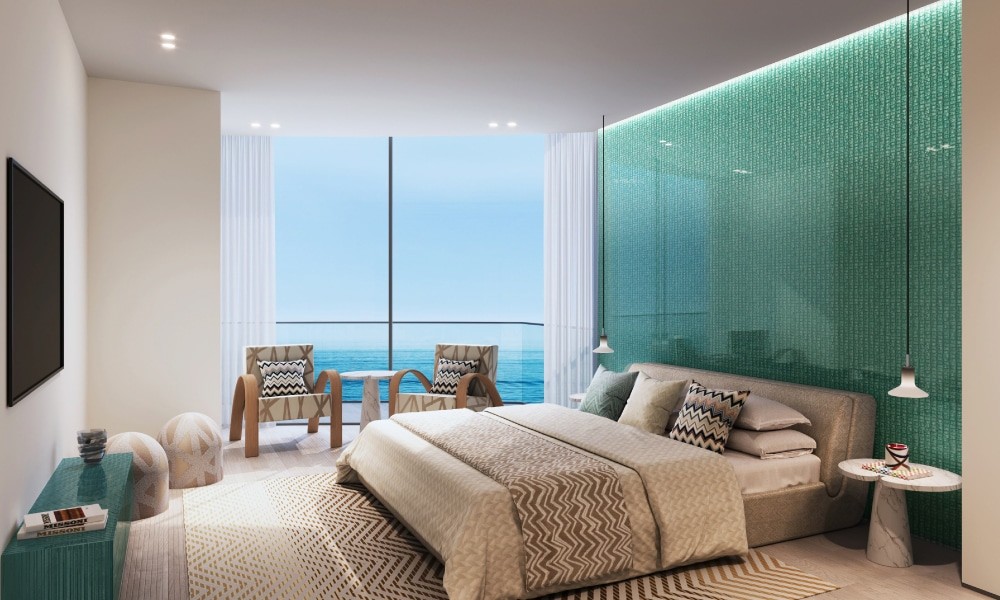 Stylish bedroom with a large window overlooking the ocean, designed by Trio Isle by Durar.
