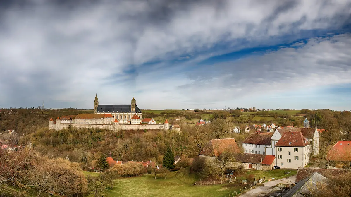 Blick über Schwäbisch Hall mit historischen Gebäuden, Grünflächen und weiter Landschaft.