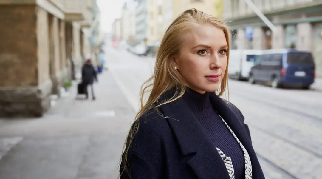 Woman wearing coat on city street in Finland University