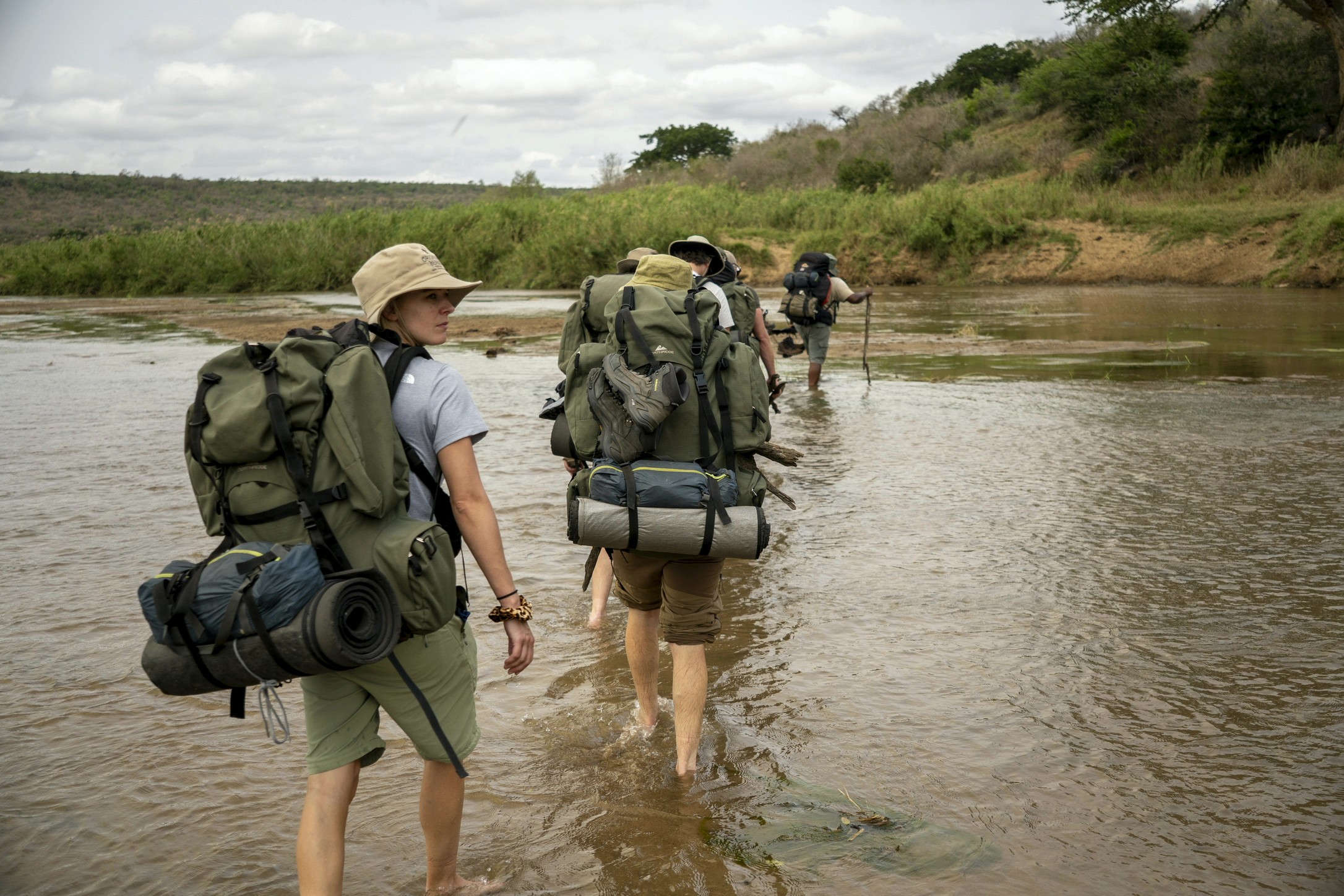 Hikers crossing a river