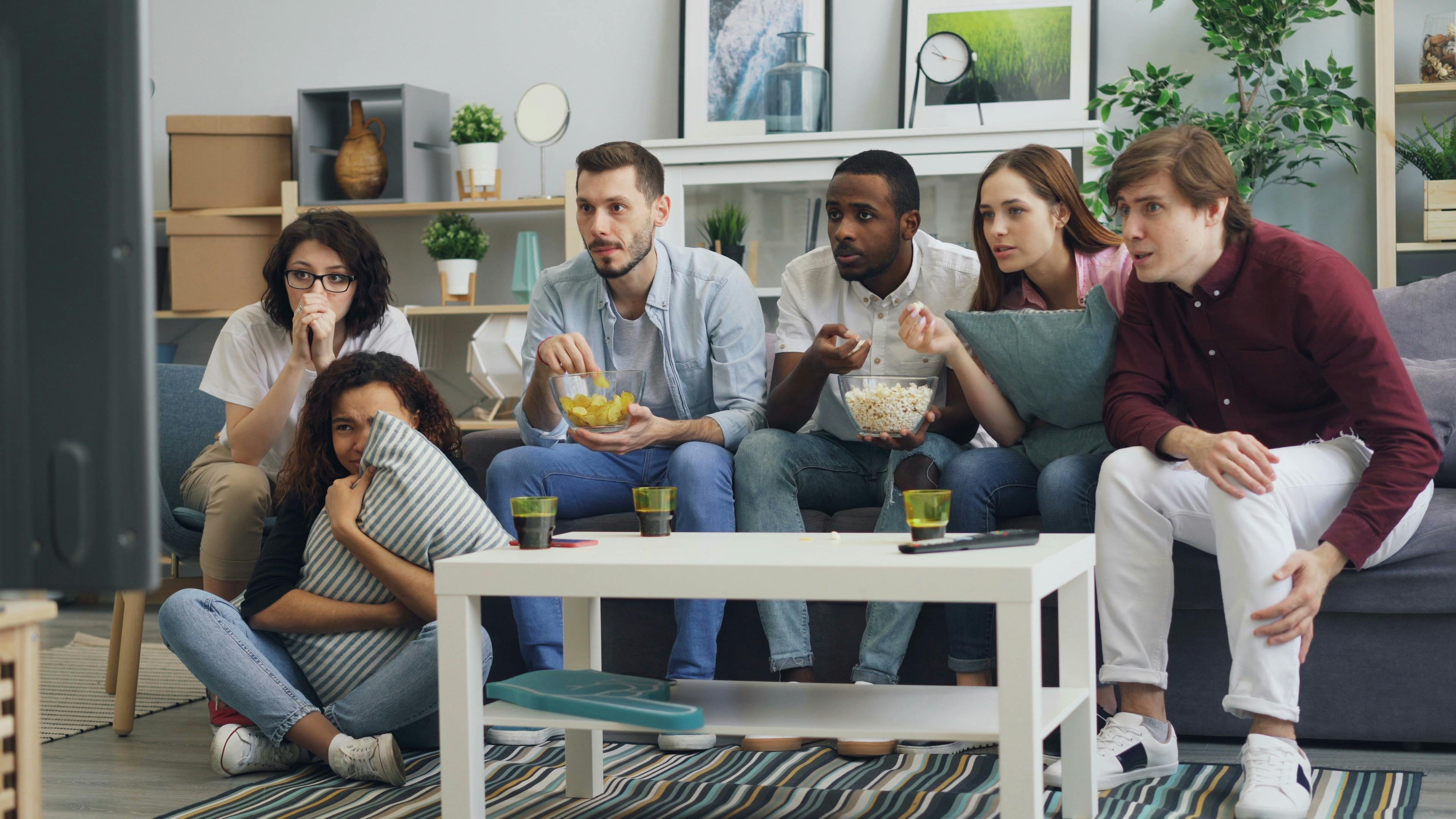 Family and friends watching TV together