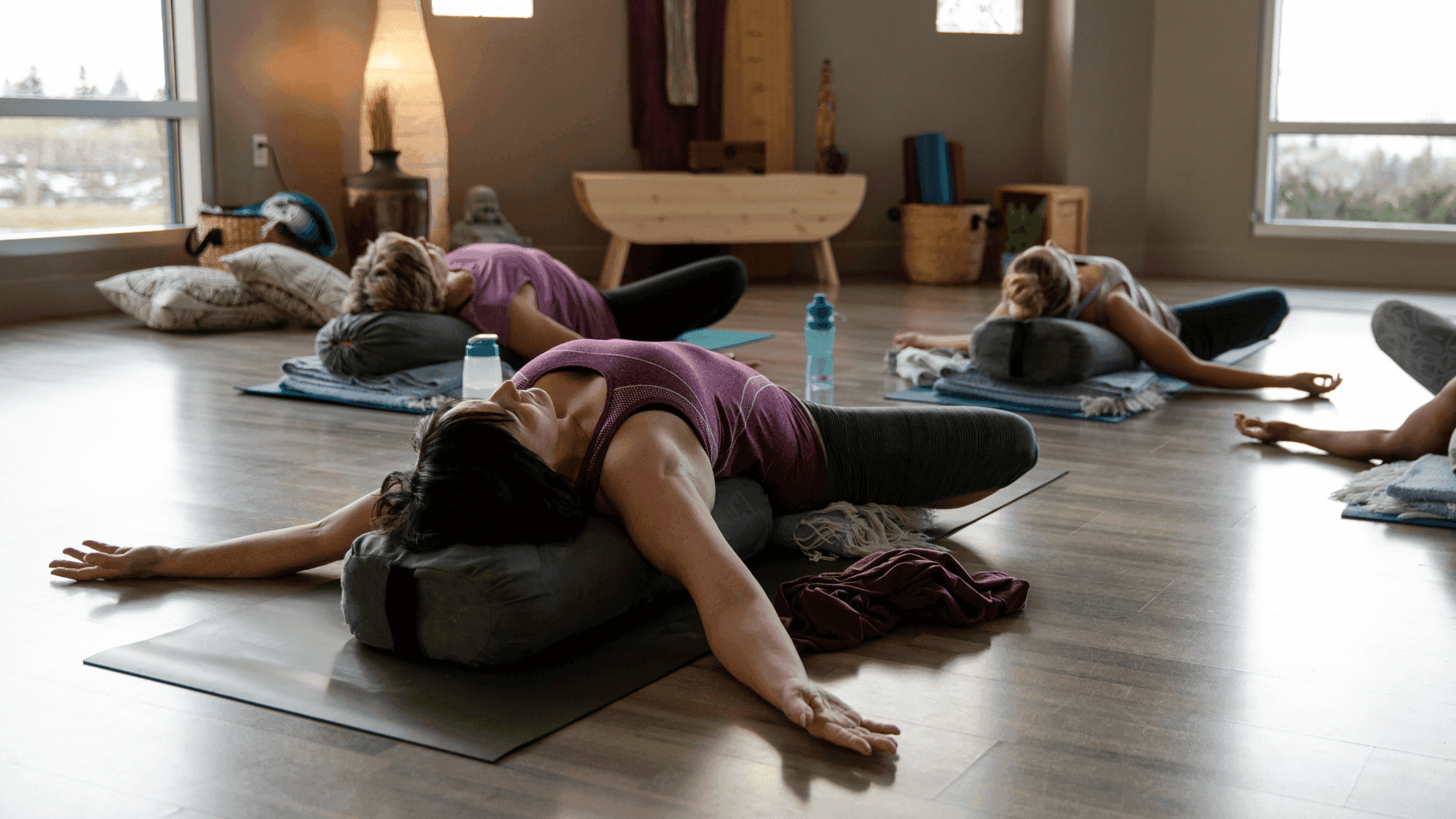 Lady in reclining butterfly pose during a menopause yoga class