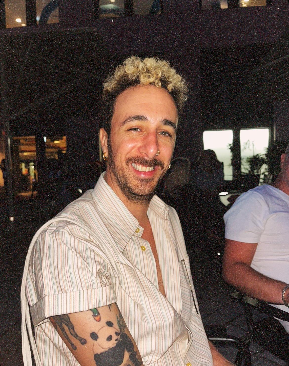 Portrait of Adi Gottlieb, smiling, in a striped shirt