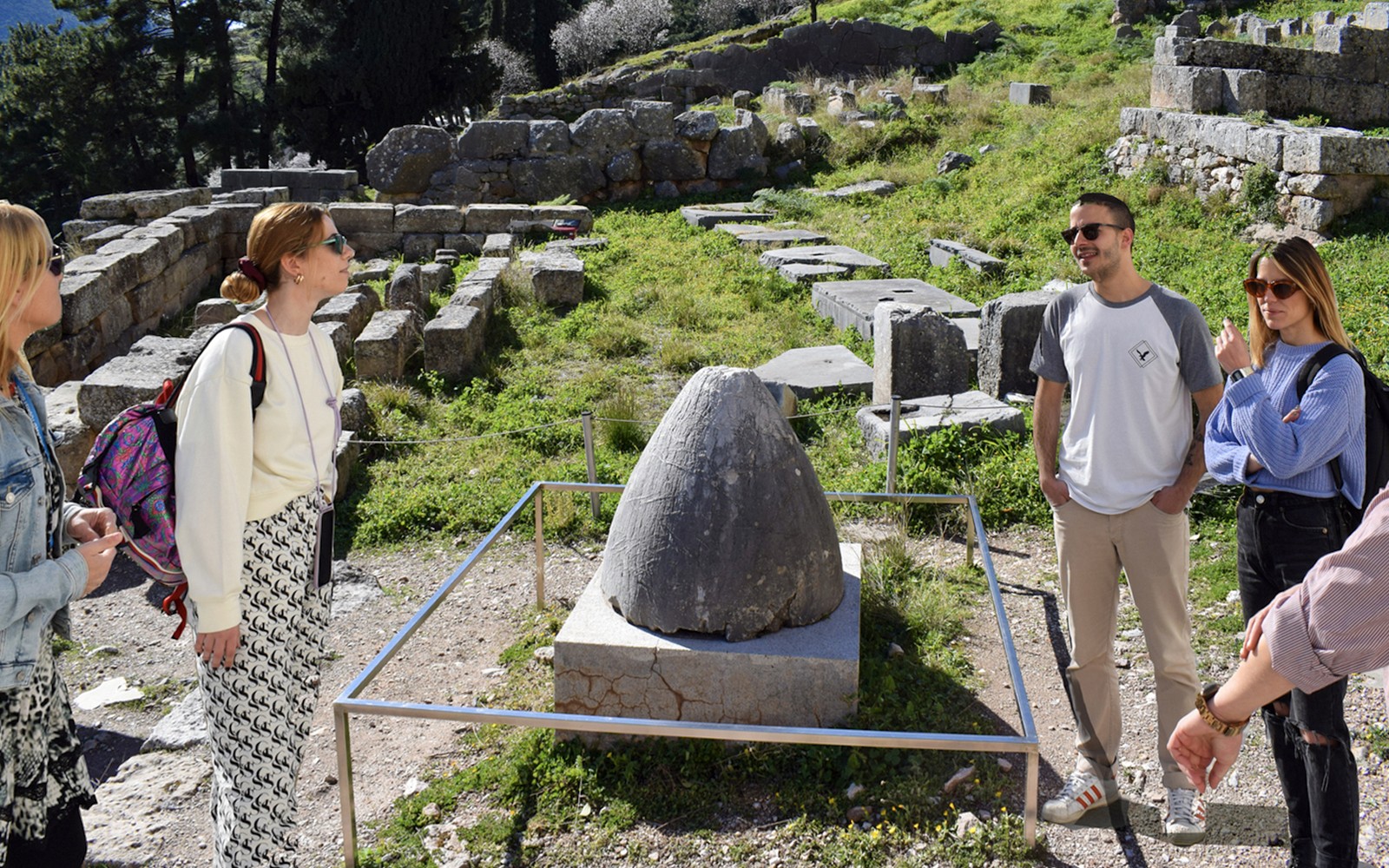 在希腊德尔斐古遗址附近,游客们正参观著名的Omphalos石。