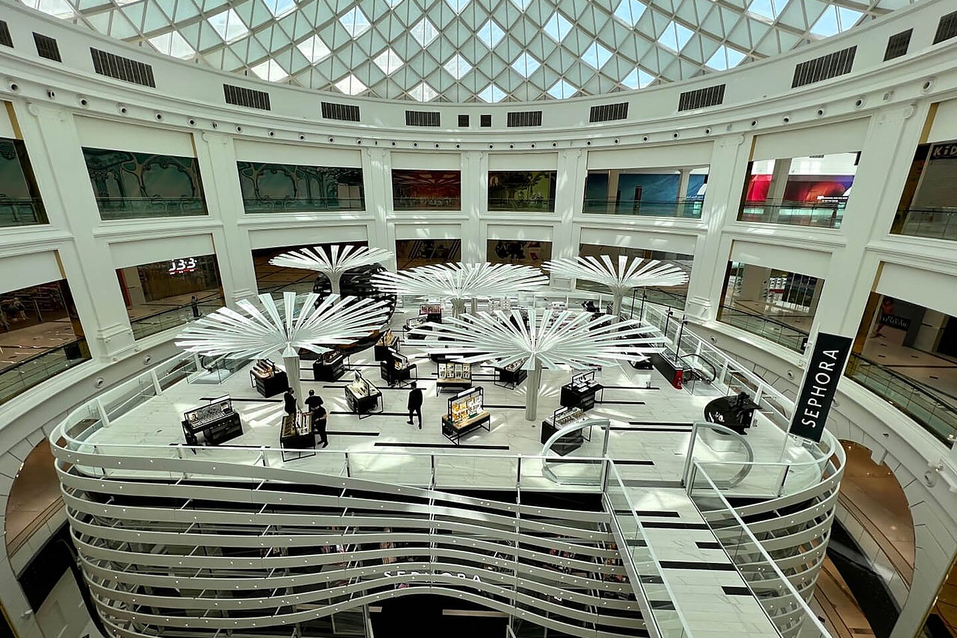 L'atrium de Sephora à Place Vendôme, à Lusail, une structure blanche en rubans sous une coupole de verre, le nom de l'enseigne gravé sur un pilier