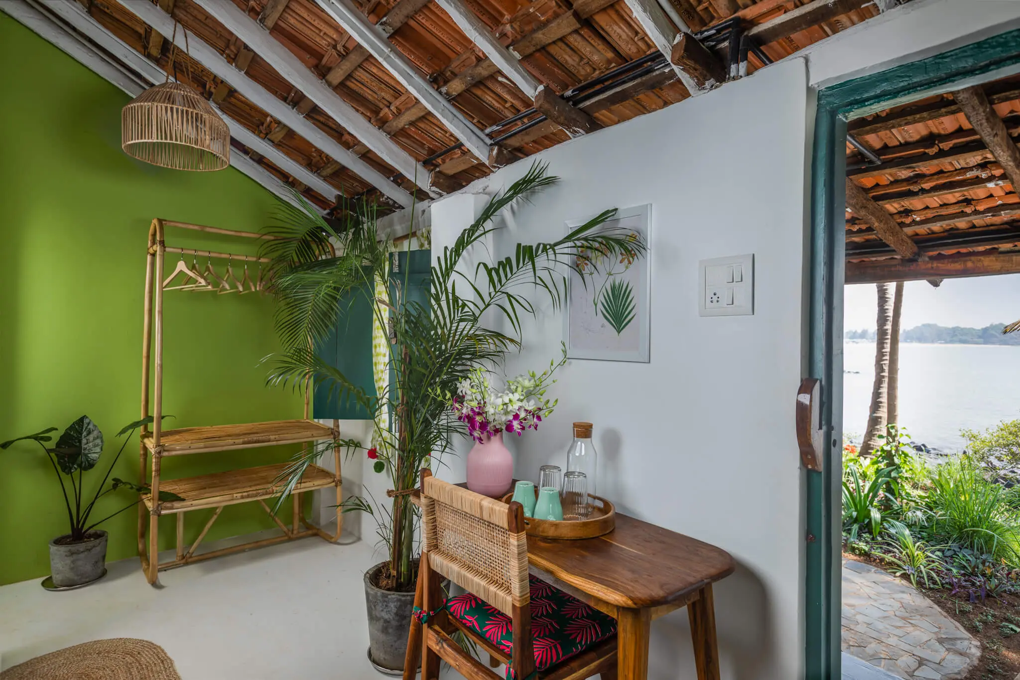 Cottage corner with cane rack and a glimpse of the sea at Casa Jaali