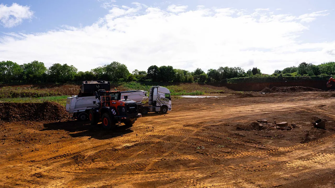 Heavy plant machinery operating on UK remediation site during land restoration and ground preparation