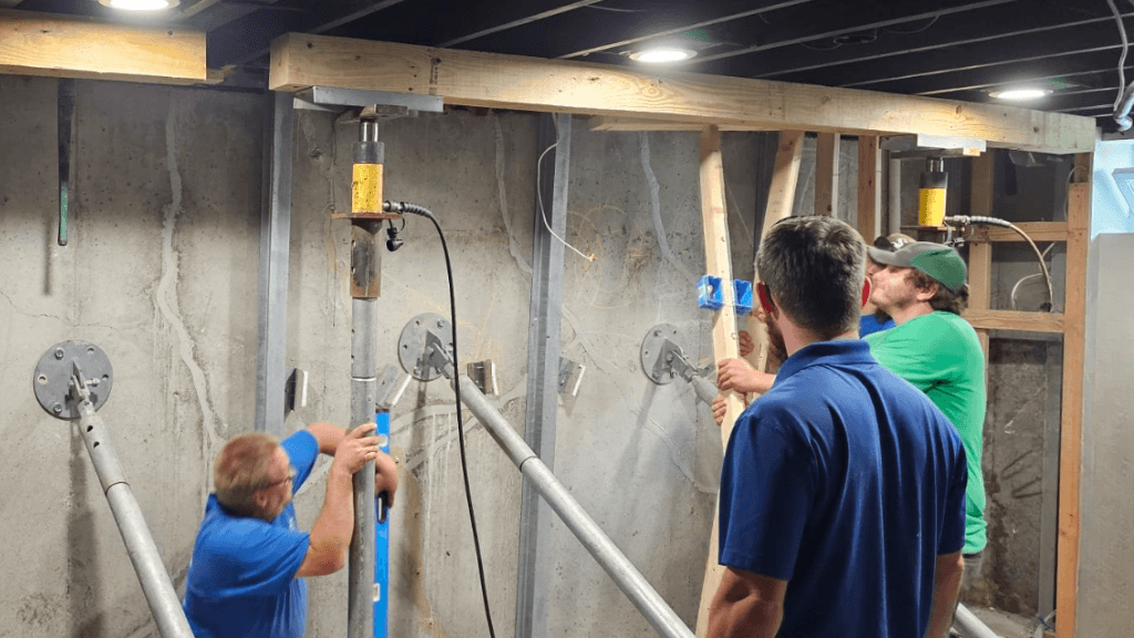 a crew braces and corrects a bowed wall