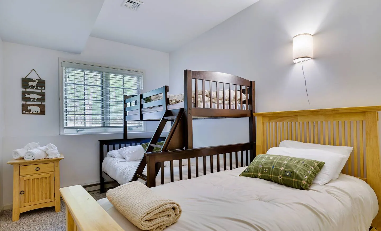 Lower level bedroom with twin over full bunk and single bed at Pop's Place