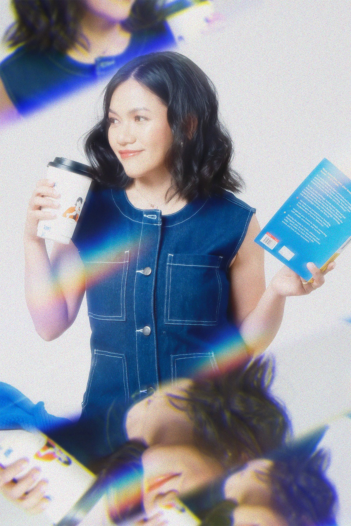 photo of Da holding a book and a cup of takeout coffee