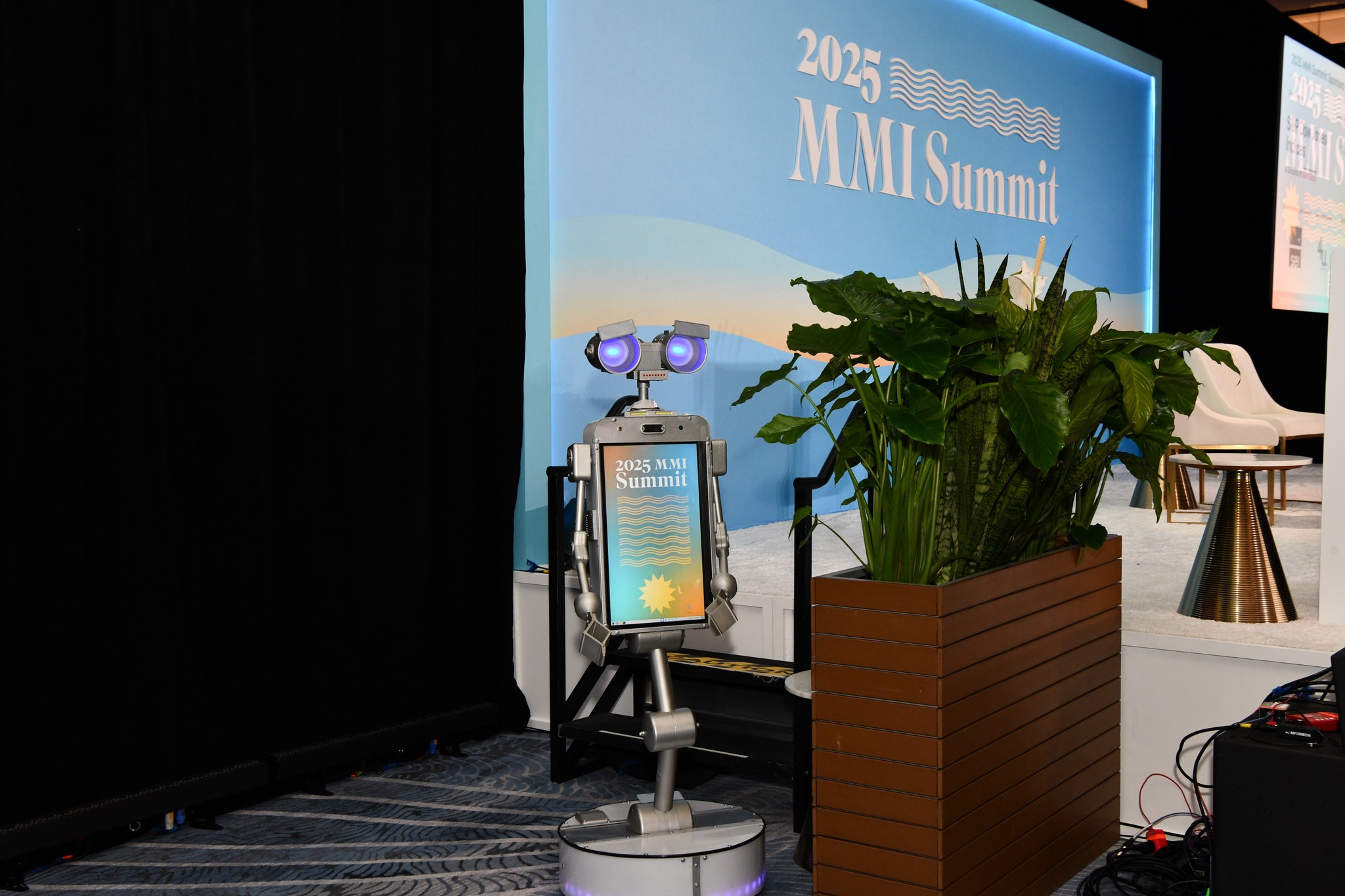 2025 MMI Summit picture of robot with MMI branding standing to side of stage