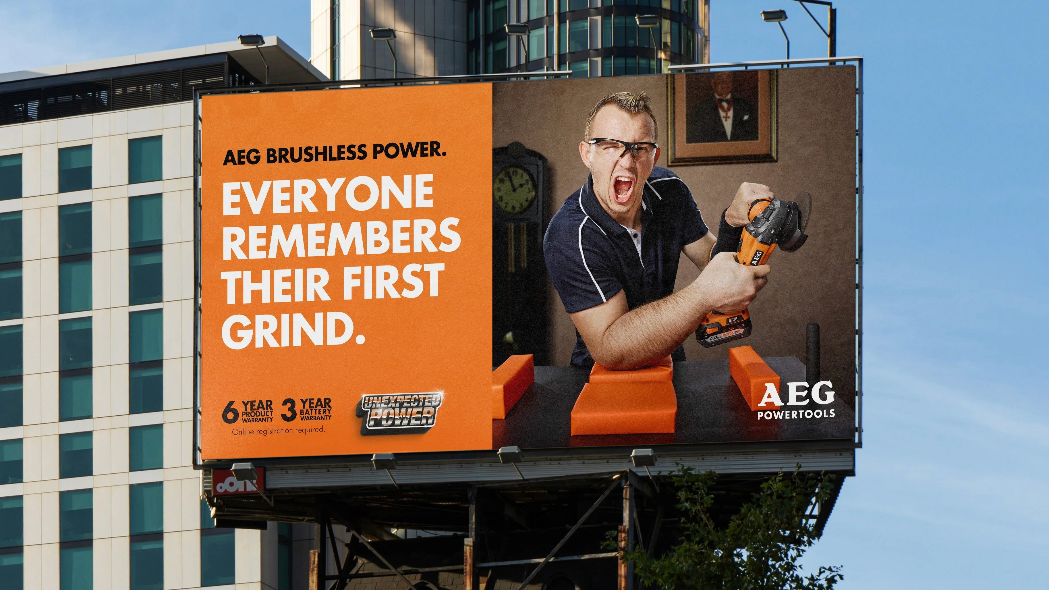 AEG Powertools billboard: 'Everyone remembers their first grind.' with a man gripping an angle grinder