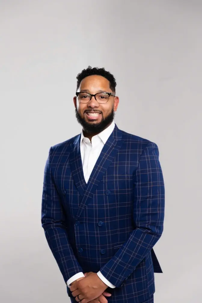 Chris Lewis, a professional mortgage lender, stands confidently in a blue plaid suit against a light background. The image conveys professionalism, trust, and approachability—reflecting his commitment to guiding clients through the home loan process with clarity and care.