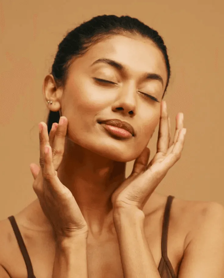 Woman gently touching her face after advanced skin rejuvenation treatment, representing IPL, Morpheus8, and HIFU procedures for smoother, youthful skin in Los Angeles.