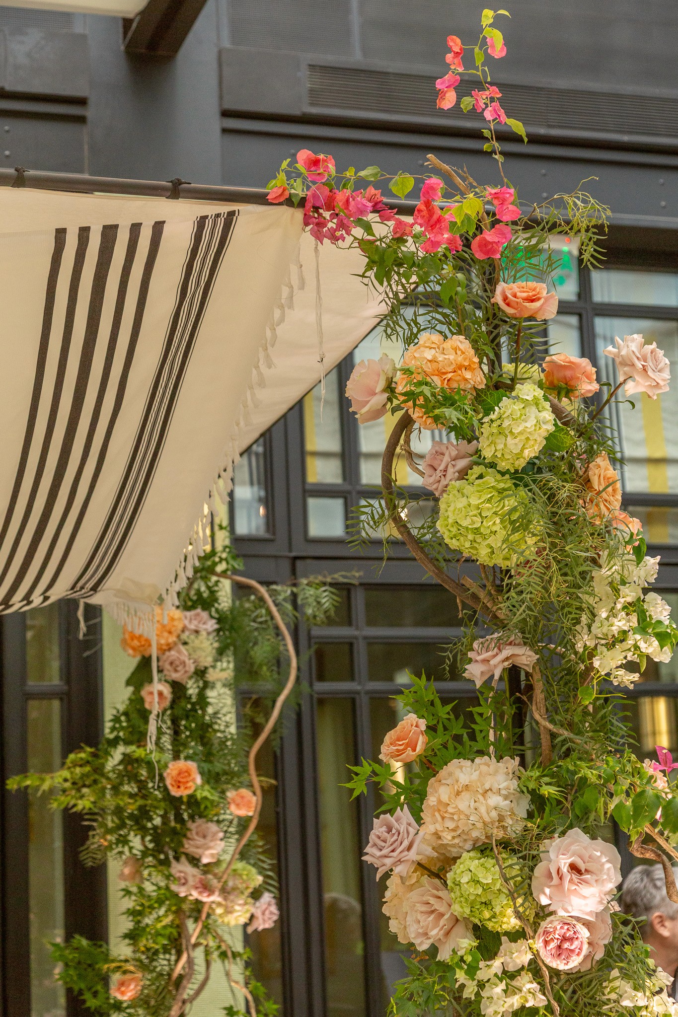 Altar decorado con flores frescas, follaje silvestre y lianas naturales en evento elegante.