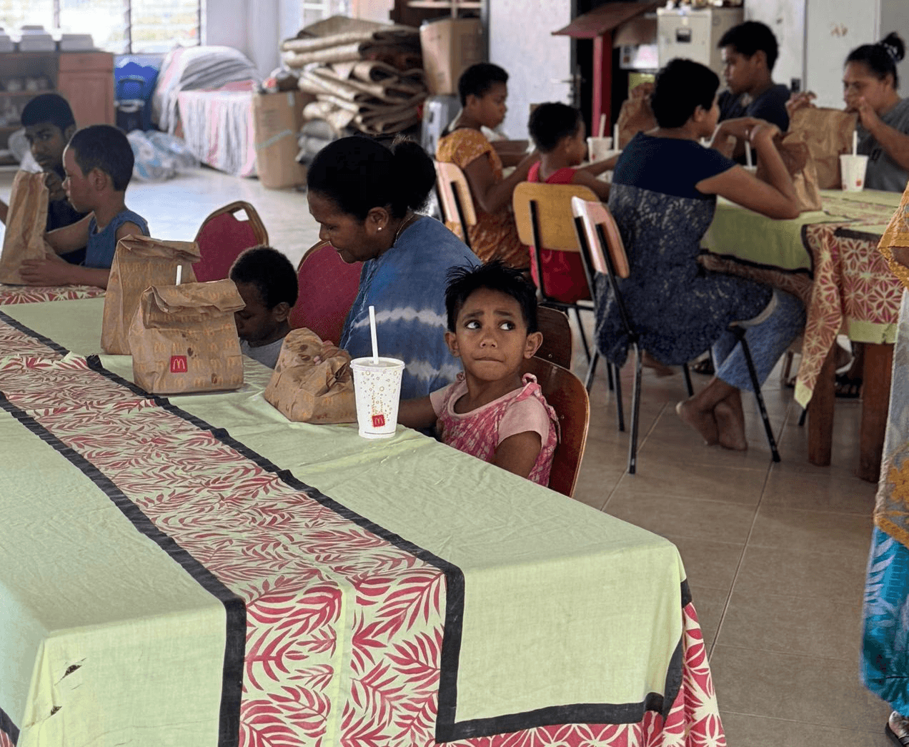 five children smiling while doing peace hand sign