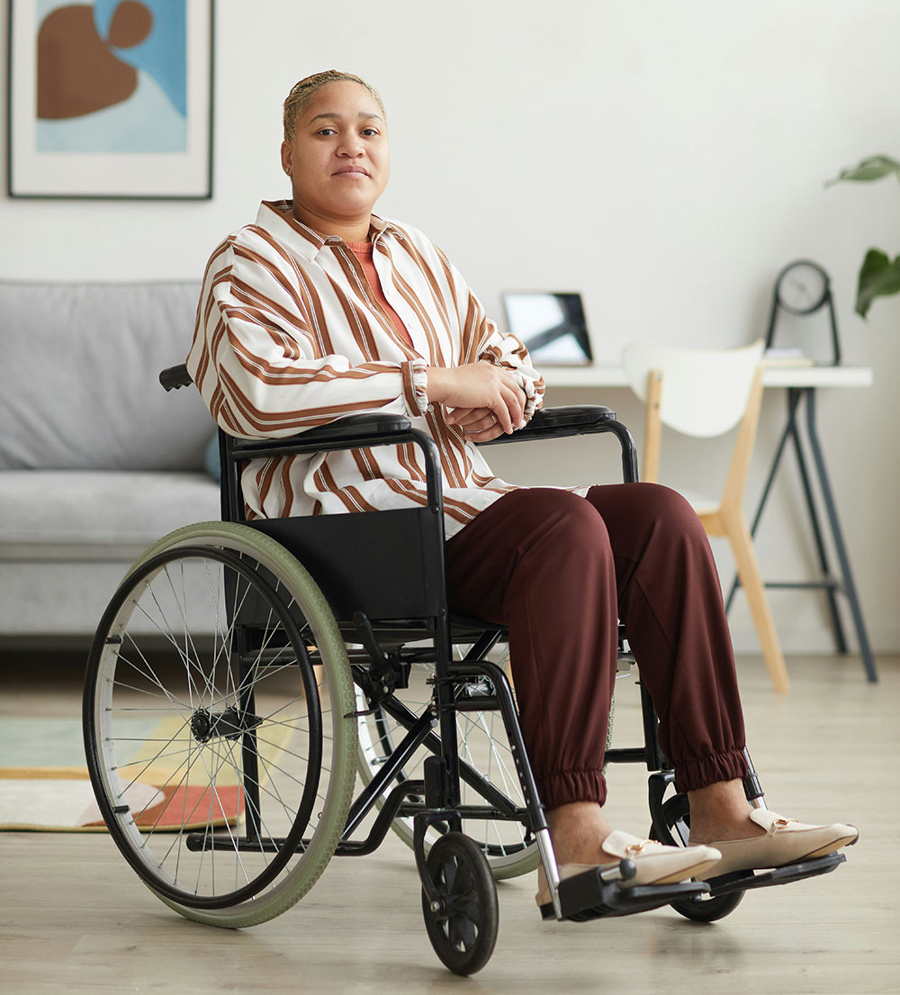 A woman sits in a wheelchair in a living room.