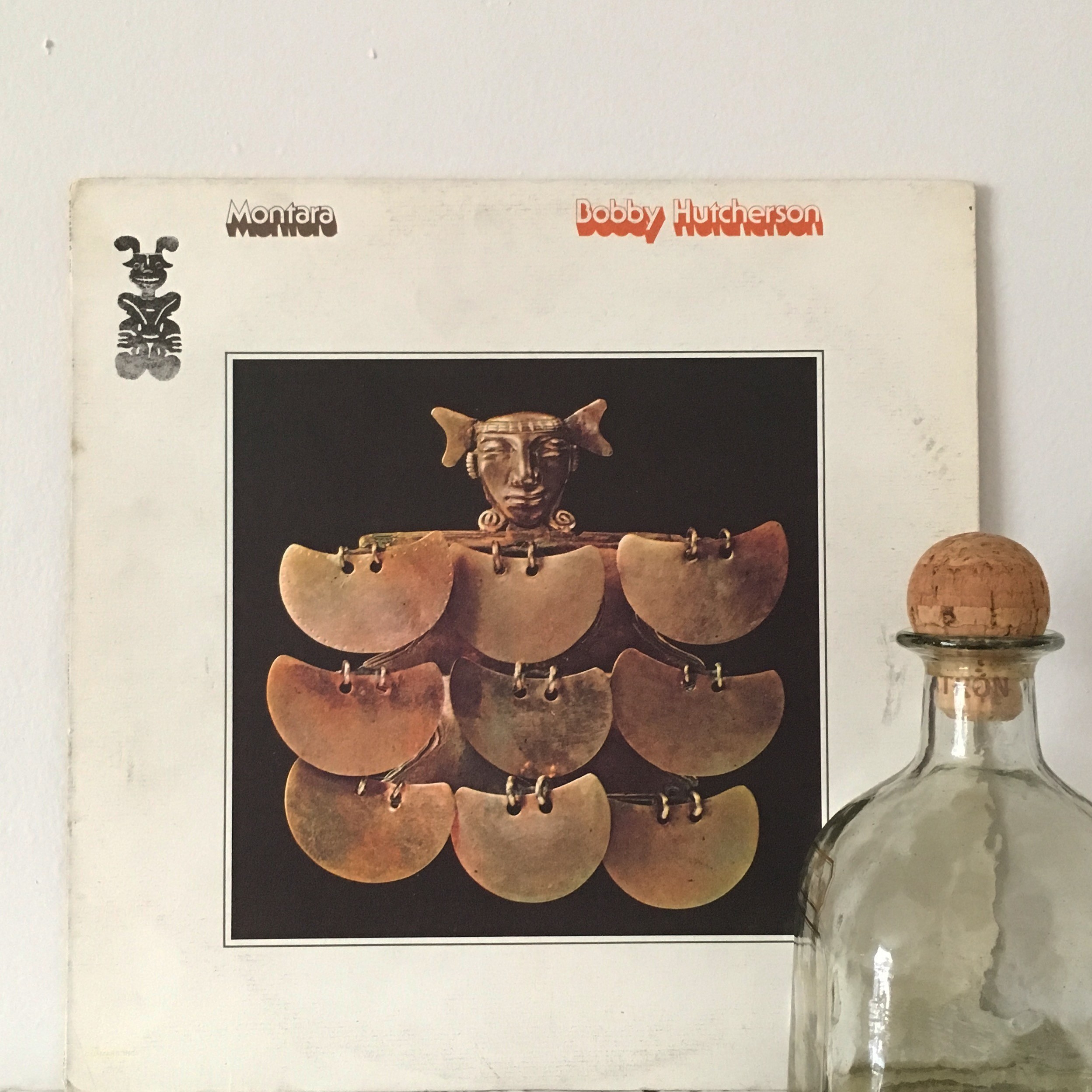 A green butterfly rests on a flower.