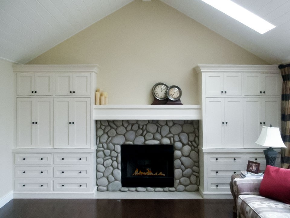 Image of Luxurious living room interior design with stone fireplace, custom cabinetry, and modern furniture by KHD Homes.
