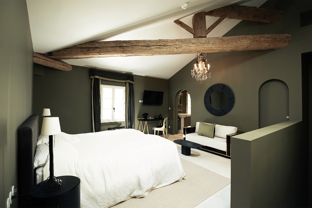 suite hôtelière, suite de prestige, suite haut de gamme, chambre d’hôtel de charme, hébergement de luxe, hébergement de caractère, rénovation hôtelière, architecture hôtelière, design hôtelier, hôtel de charme, domaine de réception, domaine événementiel, suite événementielle, hébergement pour mariage, hébergement pour séminaire, suite romantique, chambre premium, expérience hôtelière haut de gamme.  rénovation patrimoine, réhabilitation patrimoine bâti, rénovation dépendances de château, château de la Banquière, architecture du patrimoine, rénovation de prestige, conservation du patrimoine, valorisation de l'existant, architecture contemporaine et patrimoine, restauration bâtiment ancien, domaine historique, réhabilitation domaine de caractère.  charpente apparente, poutres anciennes, poutres en bois massif, structure historique conservée, matériaux anciens, pierre et bois, authenticité architecturale, volumes existants, rénovation respectueuse du patrimoine, détails architecturaux, matériaux nobles, caractère historique, charme de l'ancien, patrimoine rénové.  suite sous charpente, chambre avec poutres apparentes, volume cathédrale, plafond mansardé, architecture intérieure patrimoniale, chambre de caractère, suite en double hauteur, architecture intérieure haut de gamme, aménagement sur mesure, design intérieur contemporain, décoration raffinée, élégance intemporelle, ambiance chaleureuse, atmosphère intimiste, confort hôtelier.  mobilier sur mesure, décoration haut de gamme, design contemporain, architecture intérieure, aménagement intérieur, chambre minimaliste, matériaux naturels, finitions soignées, éclairage décoratif, miroir design, mobilier intégré, suite contemporaine, luxe discret, raffinement architectural, expérience client premium.  architecte patrimoine Montpellier, architecte patrimoine Nîmes, architecte patrimoine Perpignan, rénovation château Montpellier, rénovation domaine historique, rénovation hôtel de charme, rénovation suites hôtelières, réhabilitation patrimoine Occitanie, architecte Occitanie, agence d'architecture patrimoine, maîtrise d'œuvre patrimoine, rénovation de prestige Occitanie.