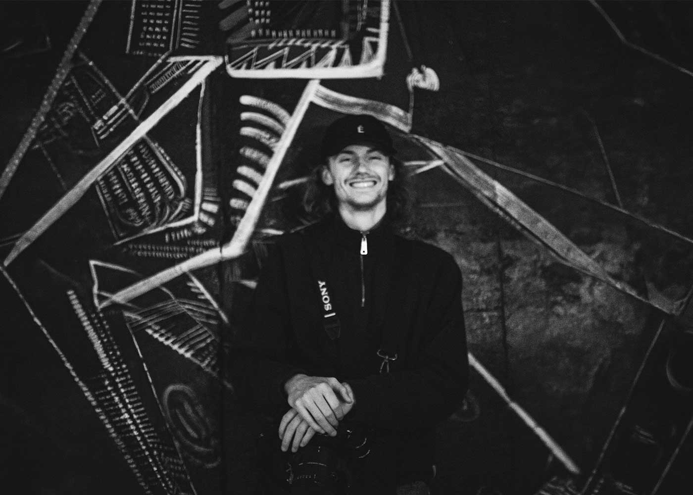 Black and white image of people working at a table with laptops, showing hands gesturing during discussion of digital content displayed on screens, with fabrica® logo in the corner.