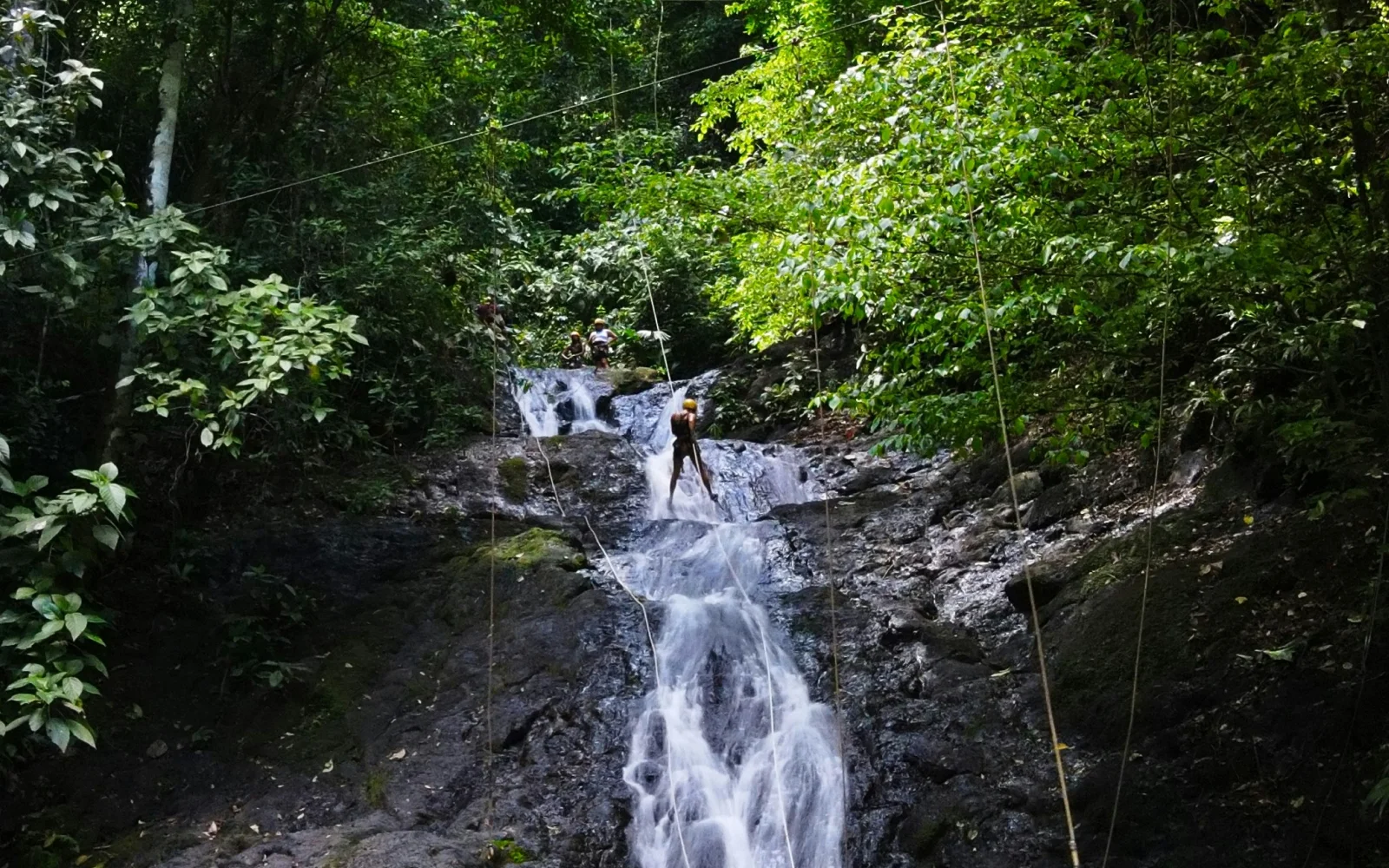People in Costa Rica rapelling down a waterfall as part of their trication