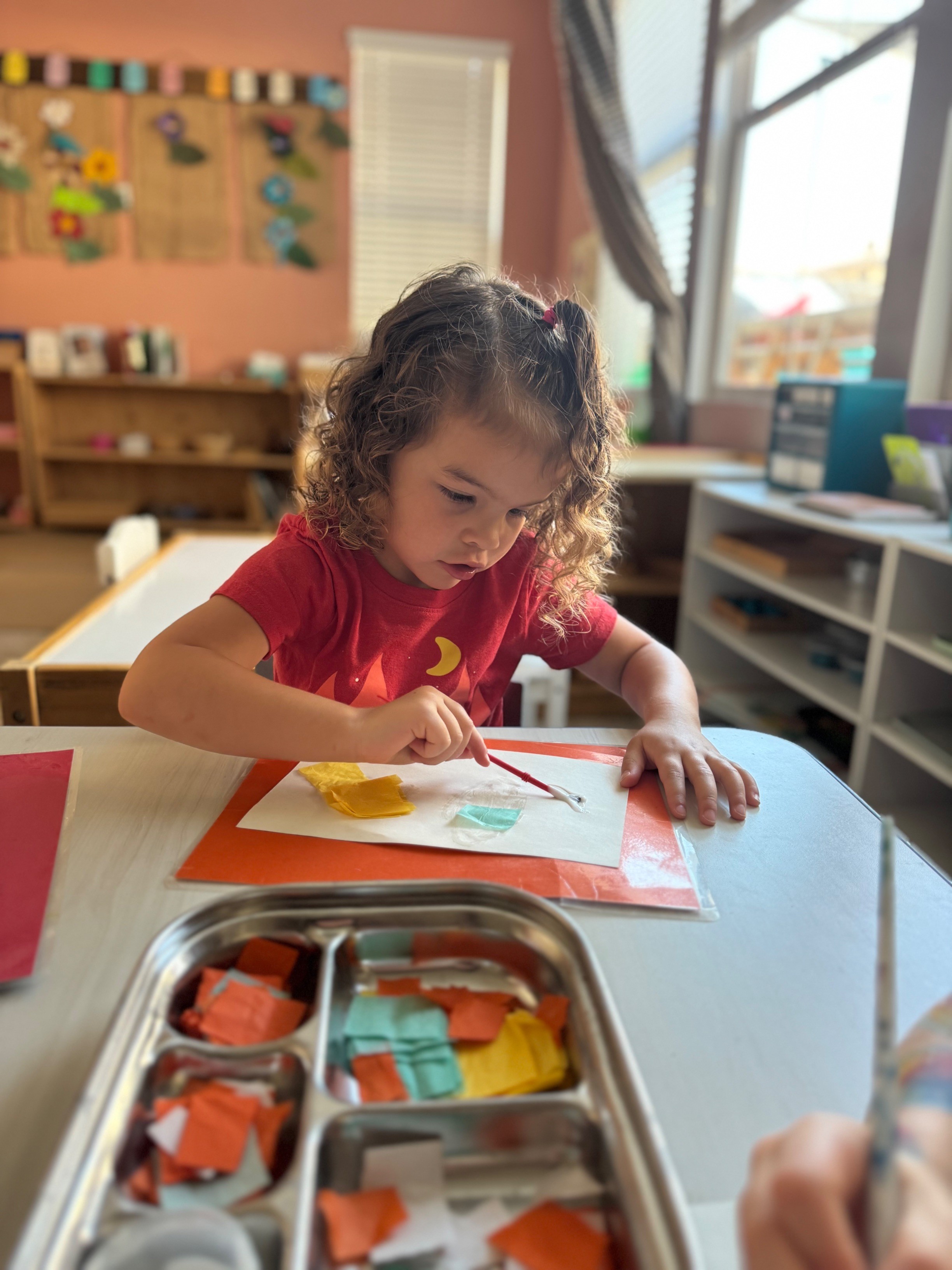 Child focused on hands-on Montessori learning in a prepared classroom environment