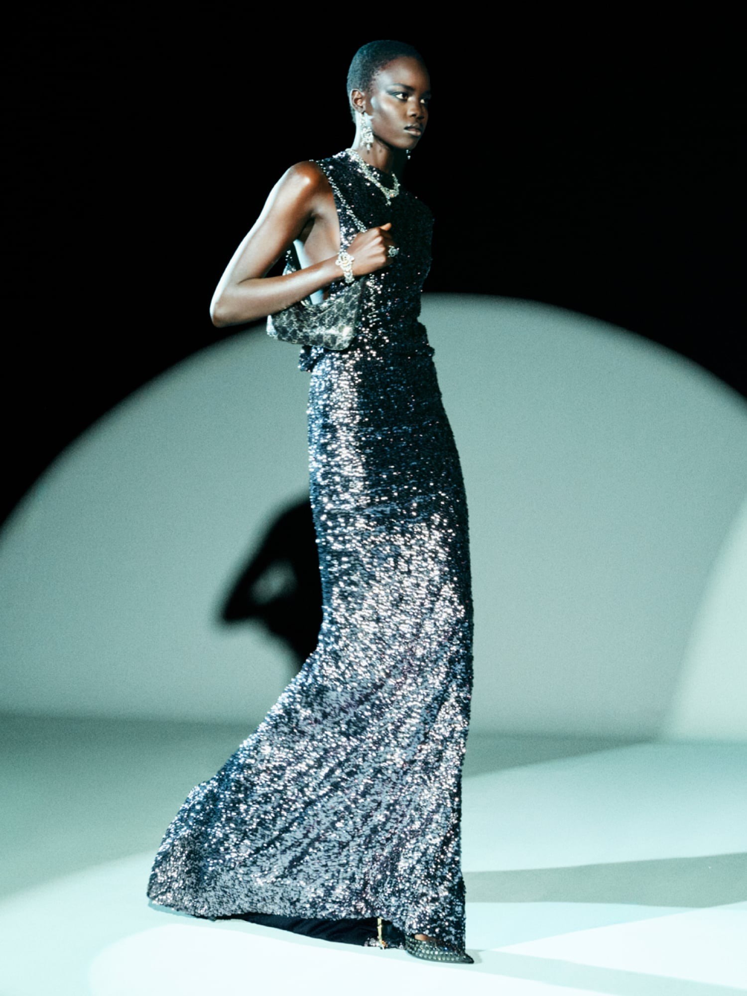 View of the French countryside through a stone villa’s open living room, with sofas and trees framing the scene