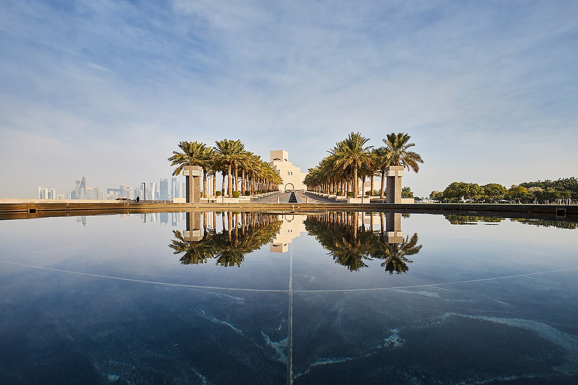 L'allée de palmiers du Musée d'art islamique de Doha, reflétée dans son bassin, une promenade que les familles retrouvent dès les vacances scolaires d'octobre
