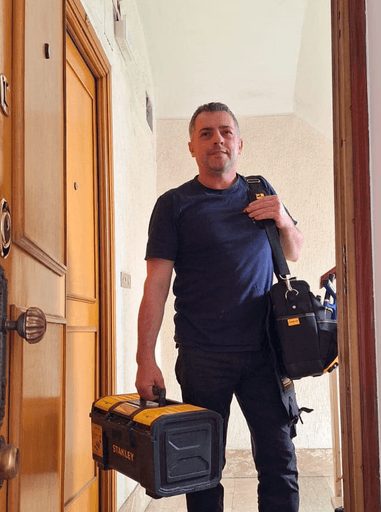 Titolare della S.A.Multiservizi Roma davanti appartamento con strumentazione tecnica e certificati