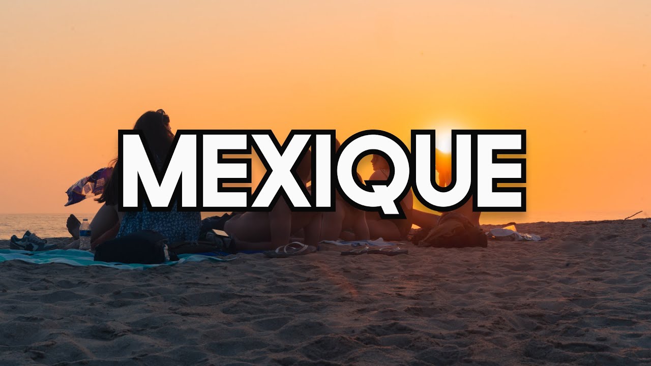 Groupe de jeunes assis sur une plage de Puerto Escondido au coucher du soleil.