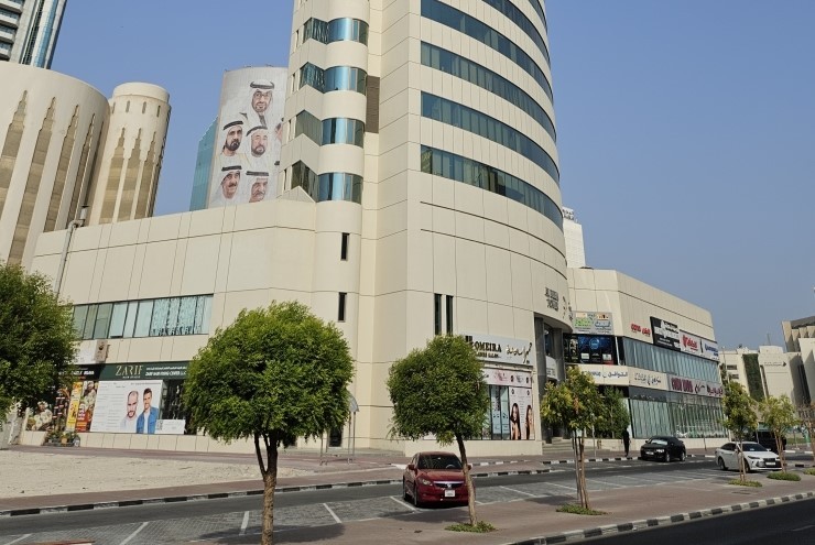 Sleek skyscraper facade under a clear blue sky, managed by professional real estate agency services.