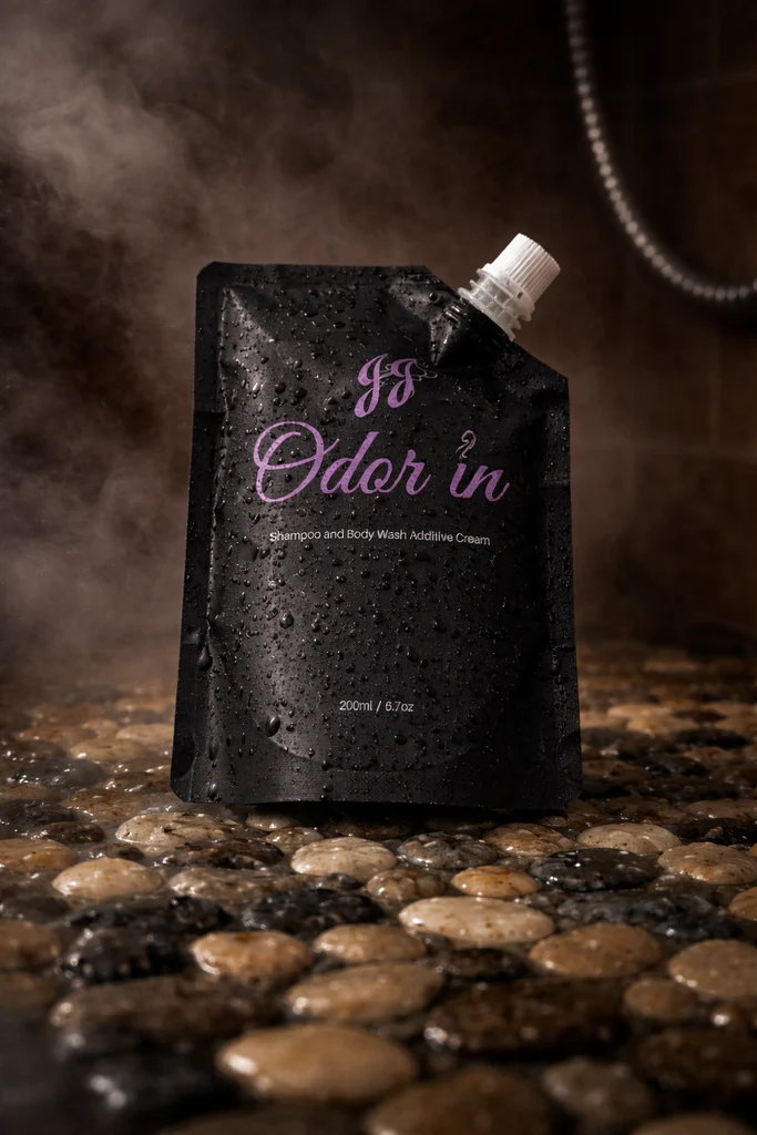 JJ Odor in body wash product with water droplets on pouch, bathroom setting