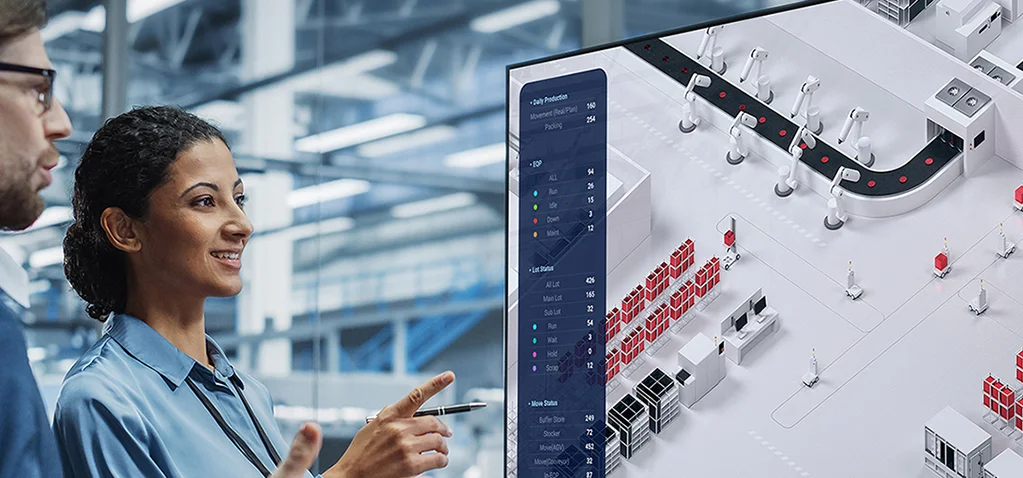 공장 자동화 시스템 화면을 보며 함께 논의하는 두 사람의 모습