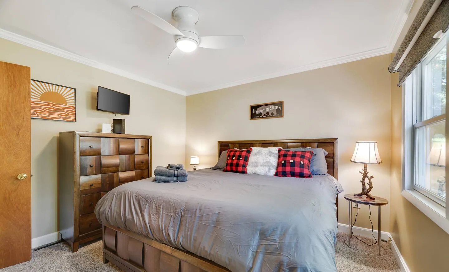 Bedroom with storage bed, gray bedding and wall TV at Barefoot Bungalow