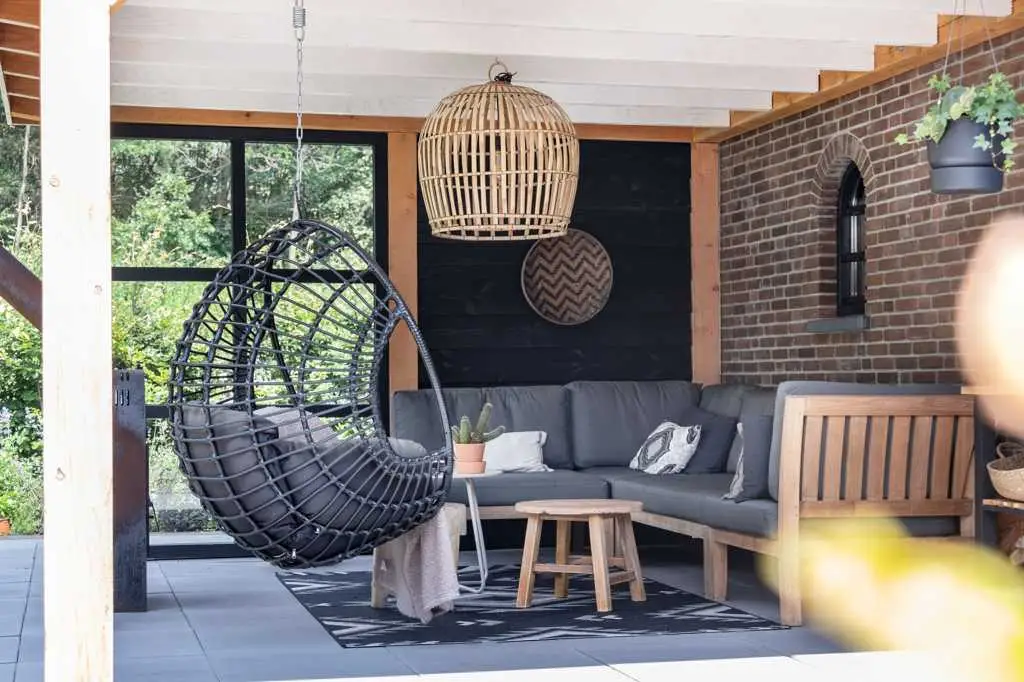 Veranda van de woonboerderij met teakhouten loungebank