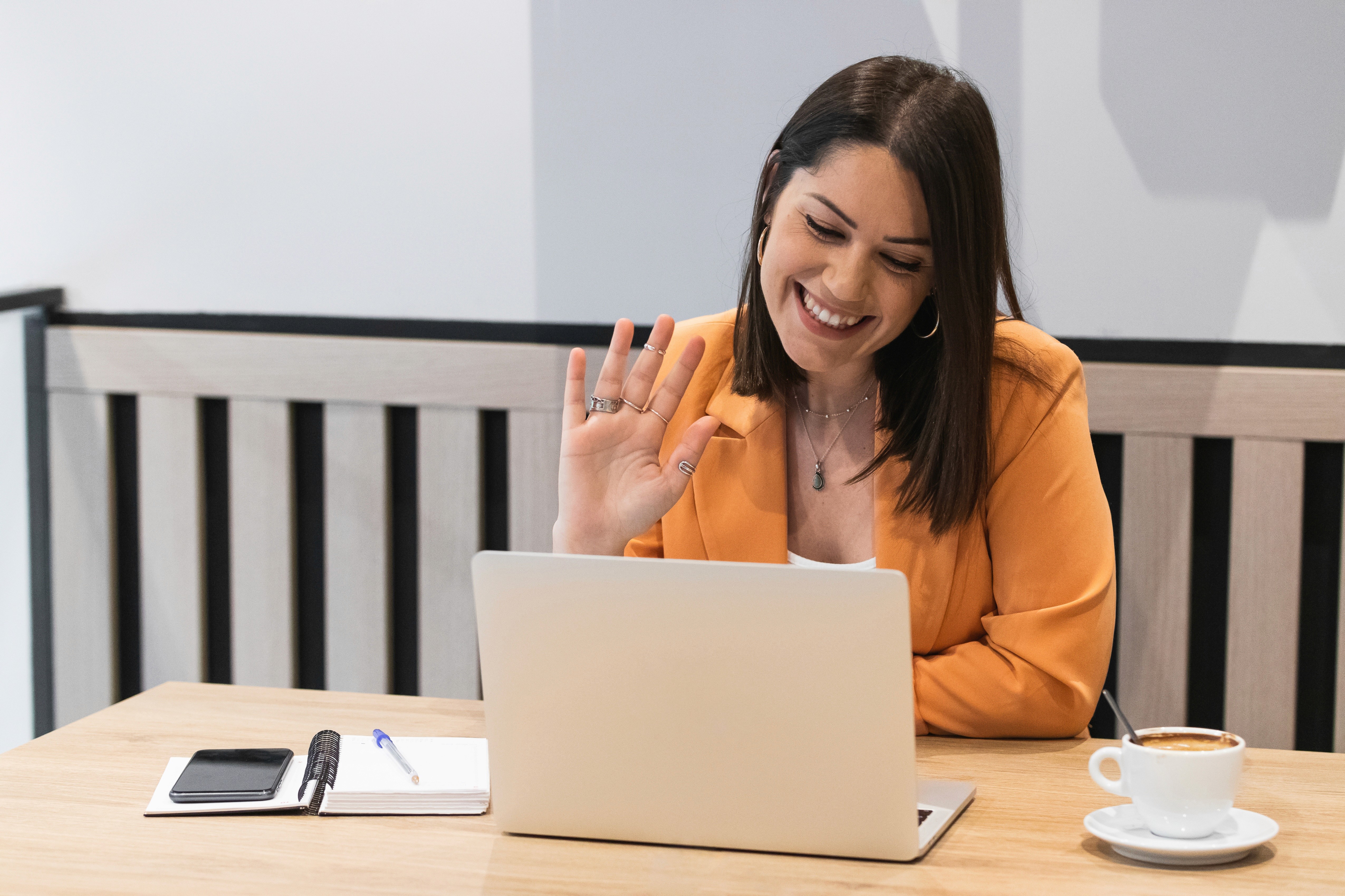 Image of woman waving to laptop screen on video call