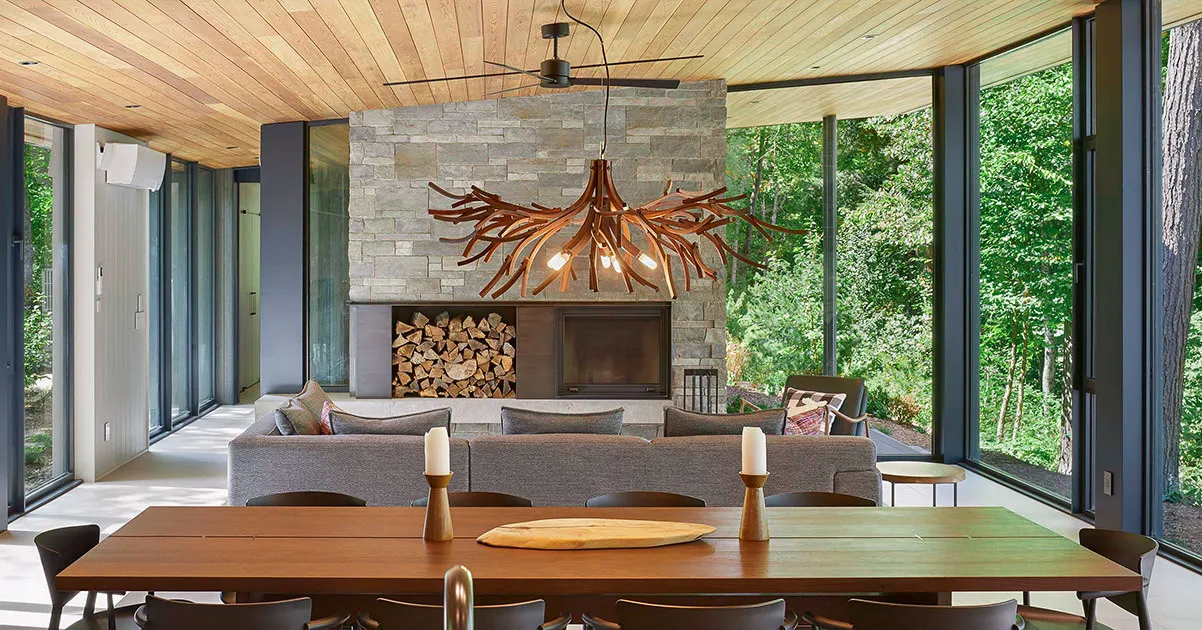 Modern rustic livingroom with granite chimney and intricate wood chandelier.