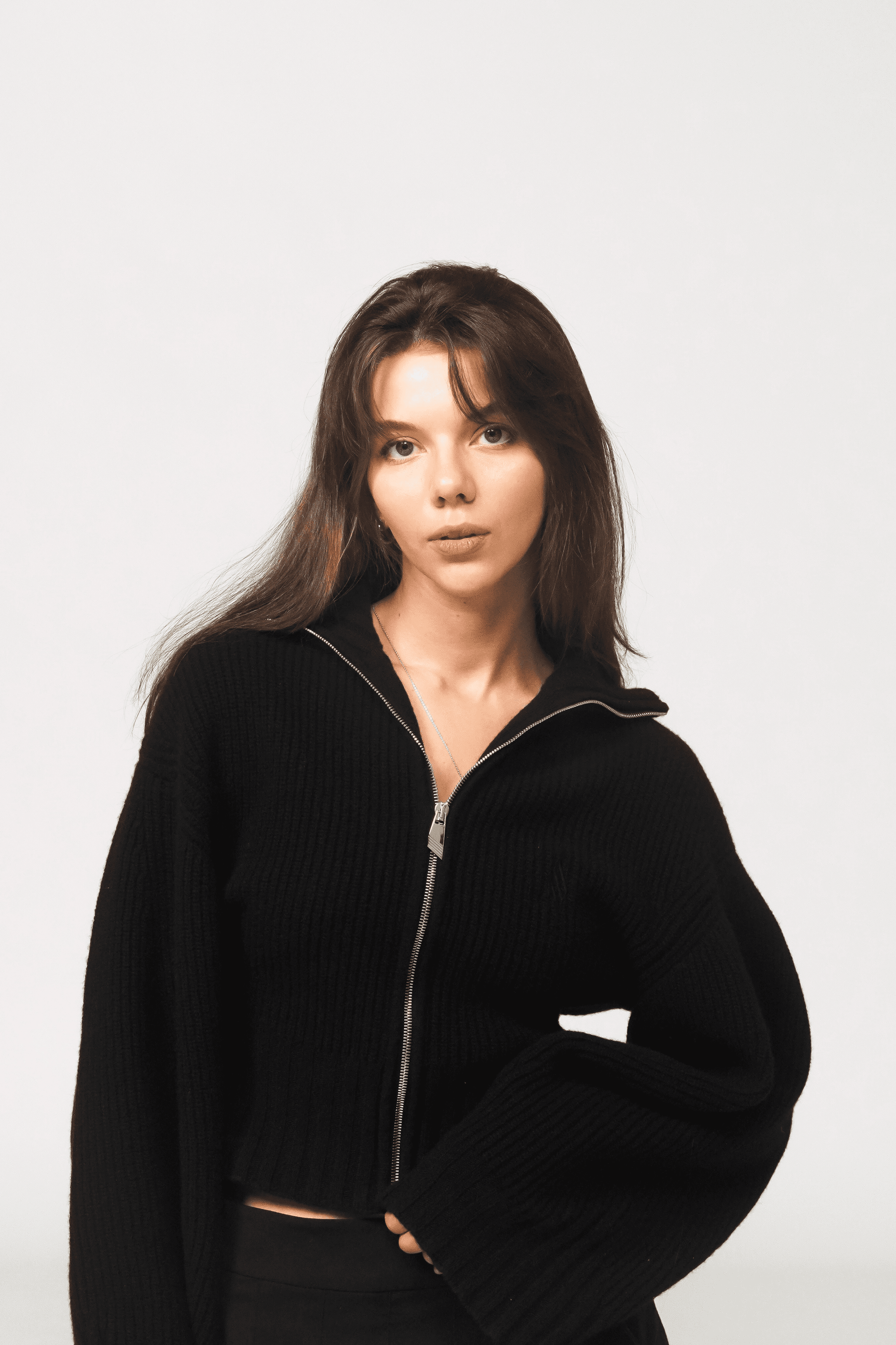 Close-up of a hand holding a smartphone with a matte dark case and a minimalist finger grip accessory