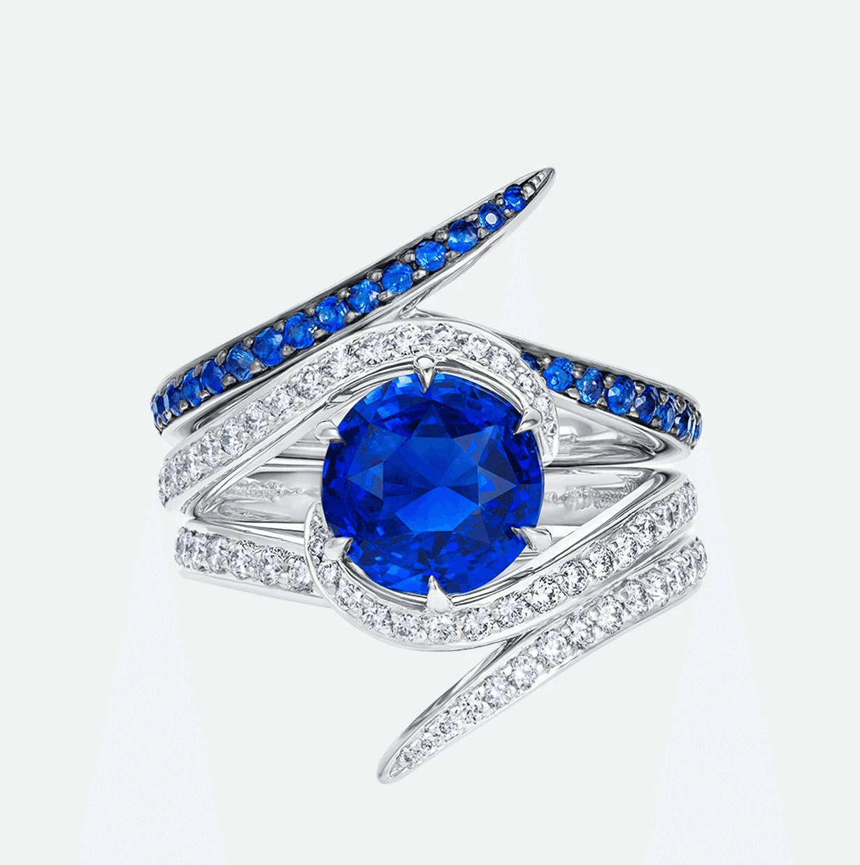 Shaun Leane fine jewellery white gold ring featuring a brilliant round blue sapphire encircled by sweeping asymmetric bands of diamonds and sapphires.