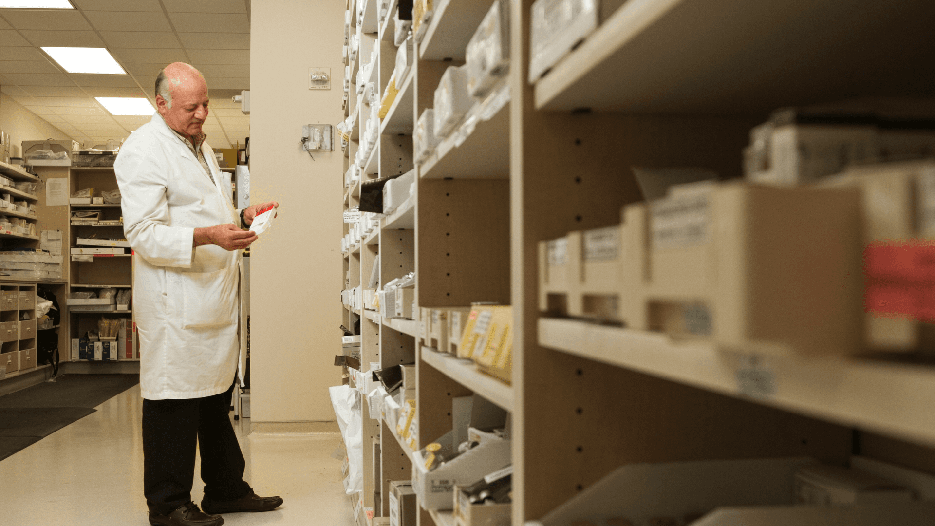 A pharmacist looking at medications on a shelf