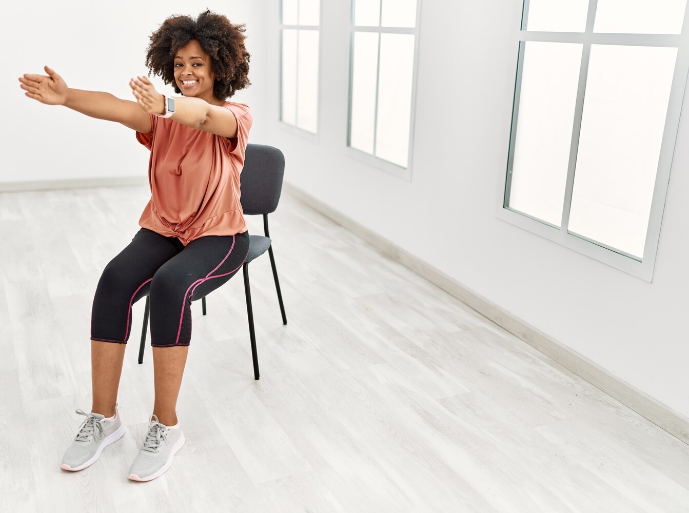 fit young woman following an interval training chair workout plan at home