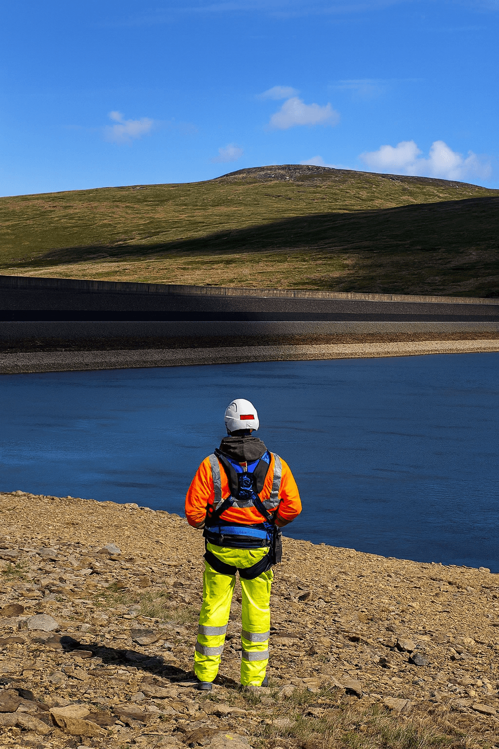 Male engineer in orange uniform and helmet standing with arms crossed Ask ChatGPT
