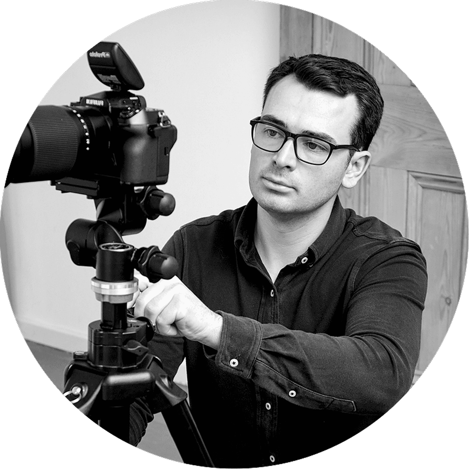 Photographer adjusting camera on tripod for photo shoot in studio.