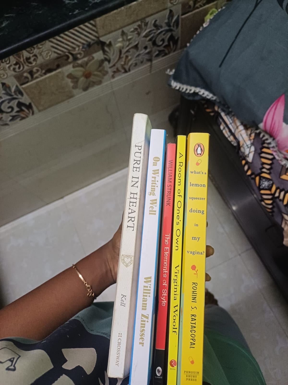 Five books held in one hand