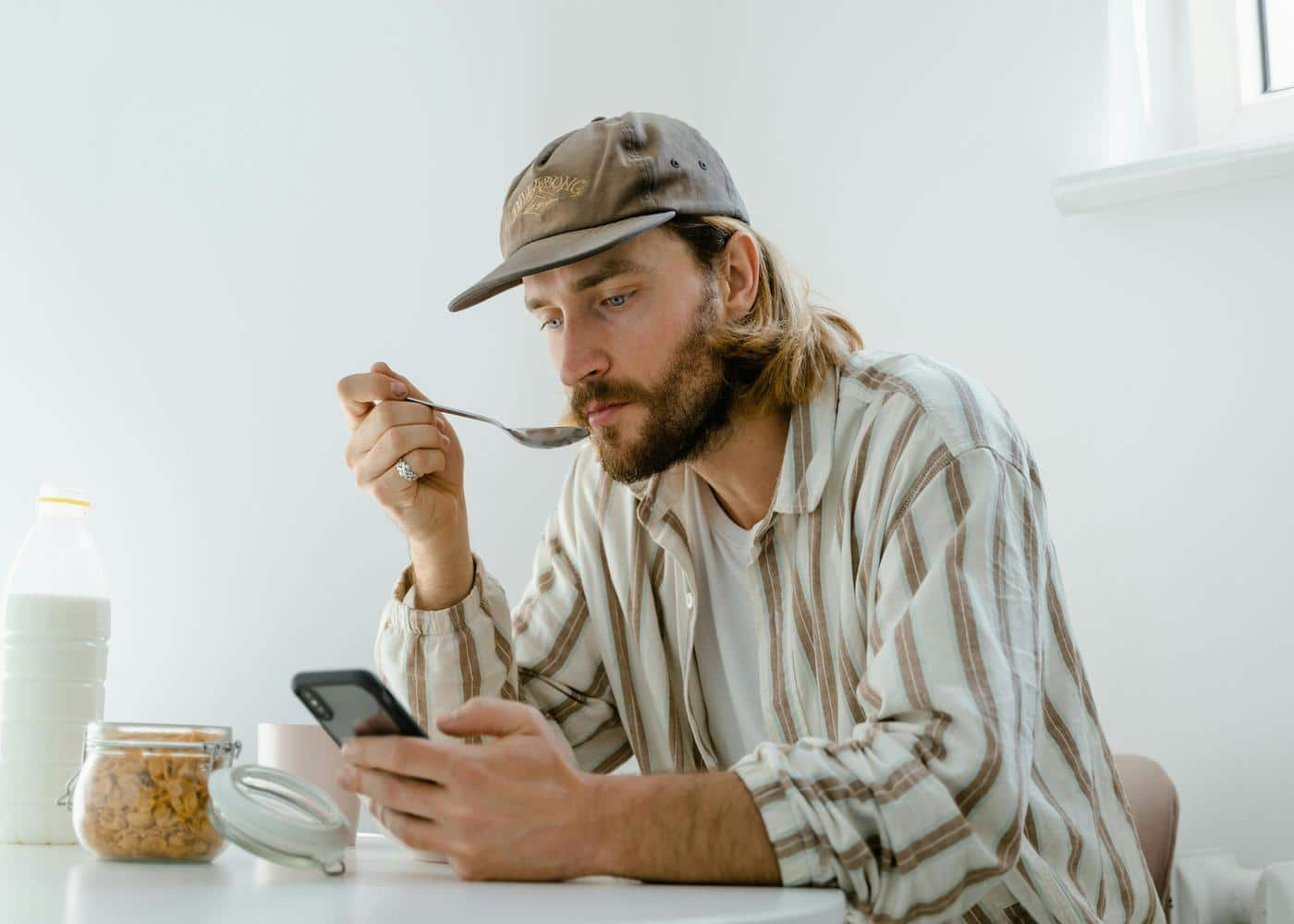 Man eating a meal with looking at smartphone