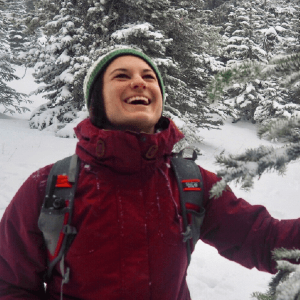 Profile picture of woman laughing in a snowy forest