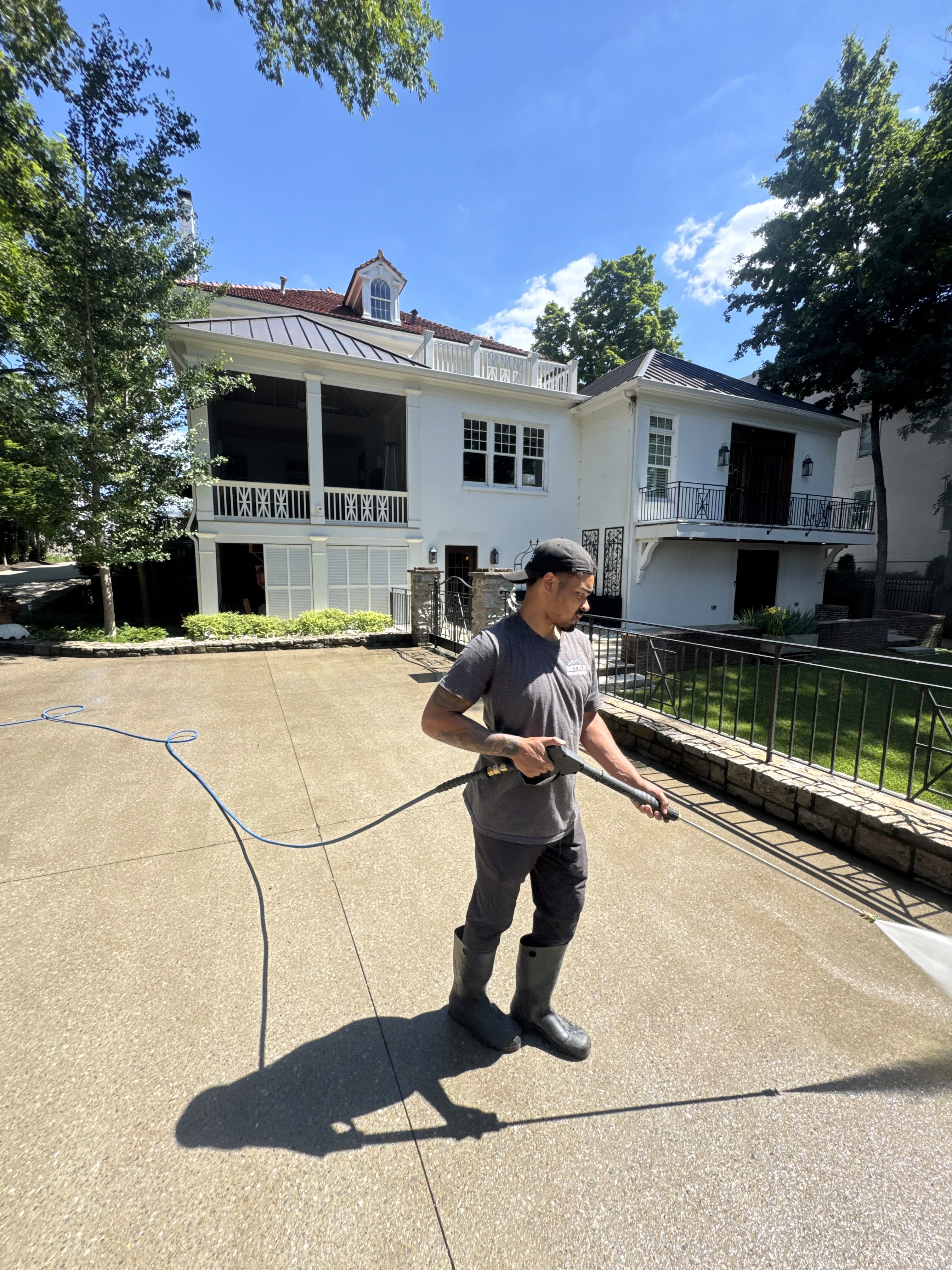Settle Solutions crew pressure washing driveway