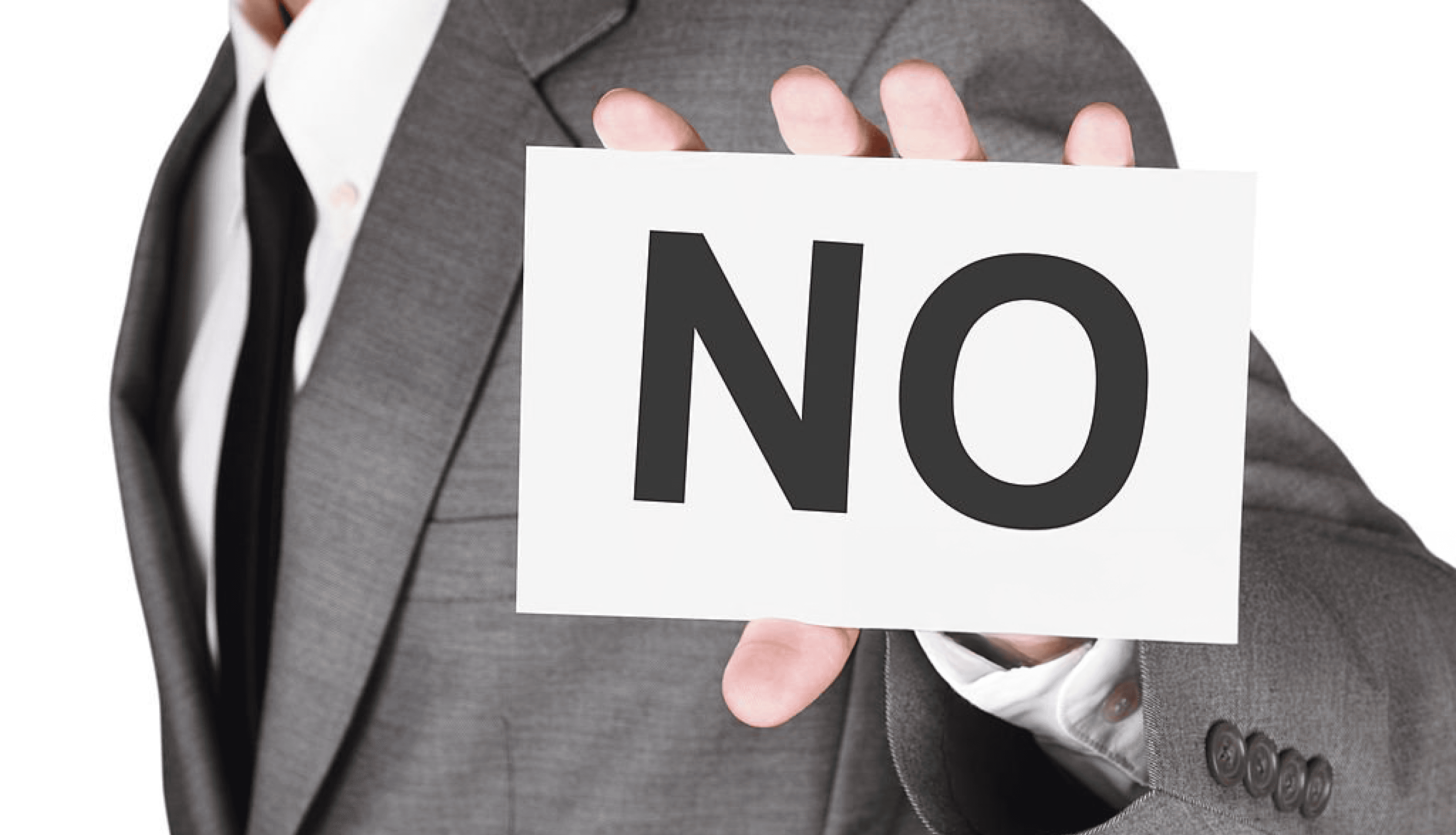 Businessman holding a 'NO' sign, symbolizing refusal or rejection in professional scenarios.